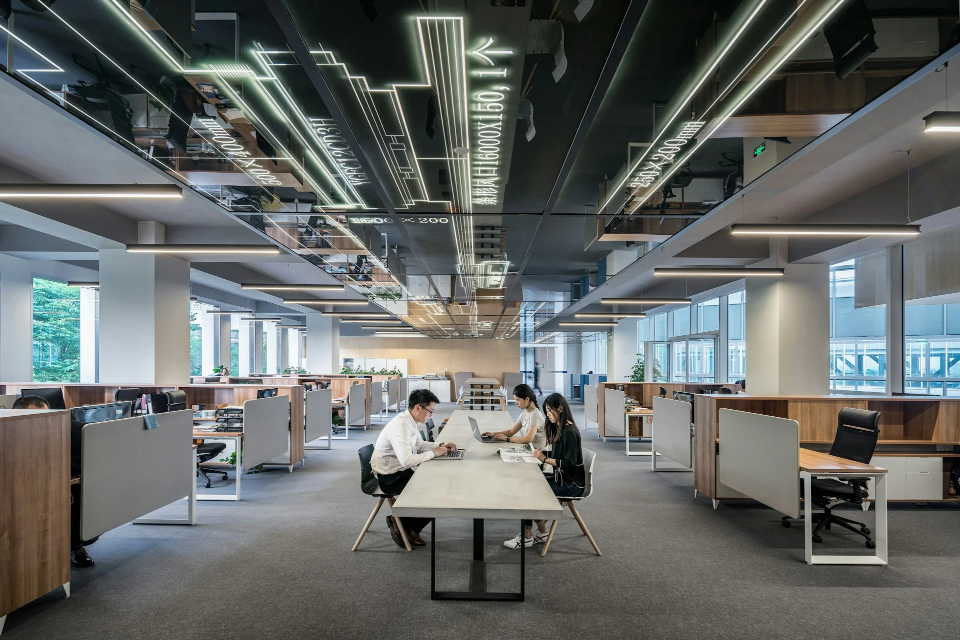 Drei Personen arbeiten im Büro.