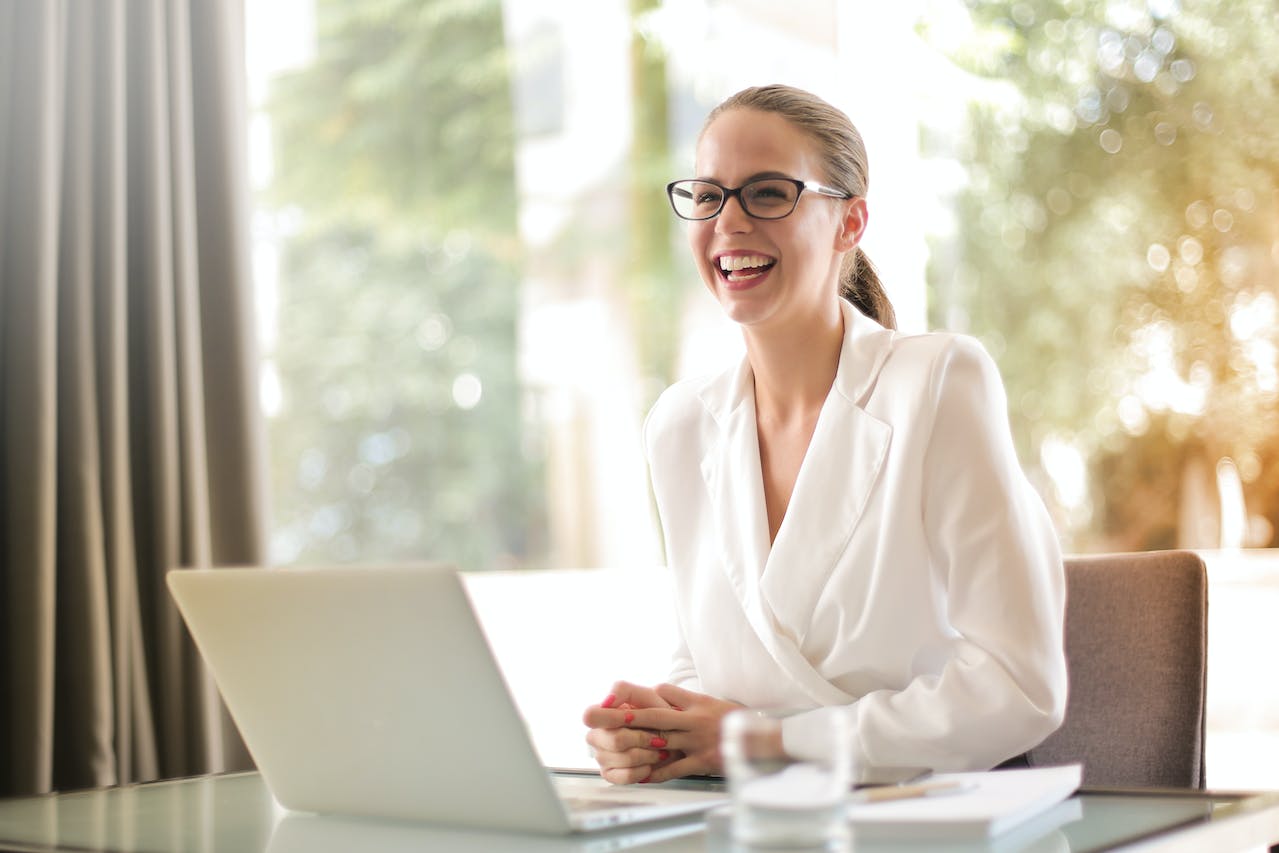 A women smiling widely while working in the office.