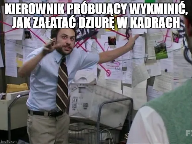 Facet próbujący rozgryźć grafiki na zabałaganionej tablicy.