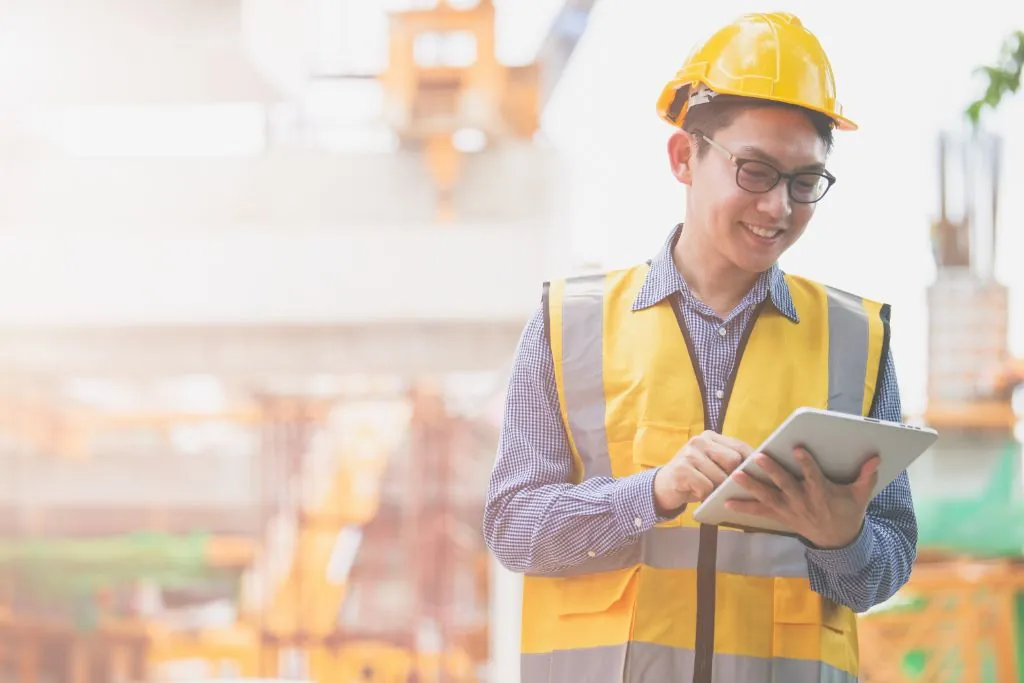 Construction software can prevent delays. Man standing with ipad.