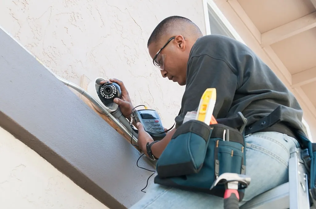 A Servus employee on-site working with a CCTV camera. 