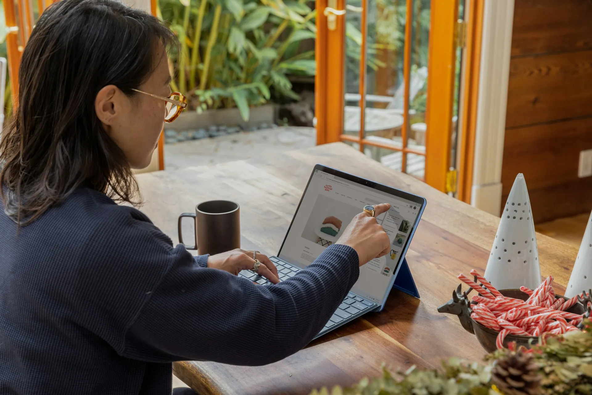 Seorang wanita sedang bekerja di laptopnya saat berada di kafe. (pekerjaan remote)